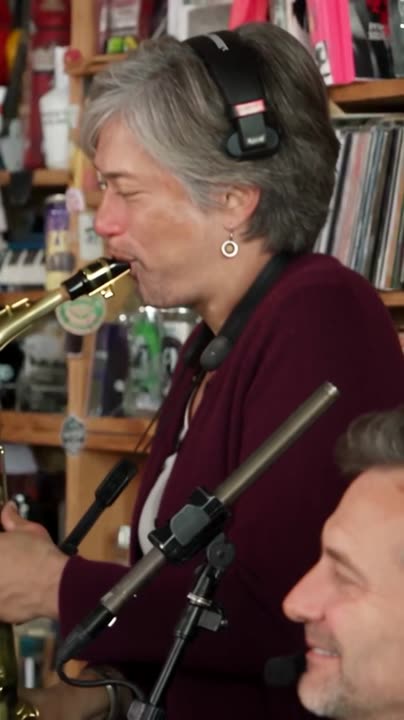 Keys and sax: a player at a red keyboard in the front row and a saxophonist.